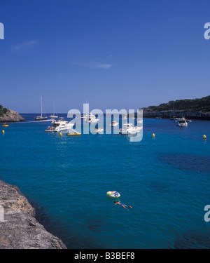 Scène dans le Parc Naturel de Cala Mondrago - avec des bateaux à moteur et voiliers à l'ancre - près de Cala D'Or, la Côte Est de Majorque. Banque D'Images