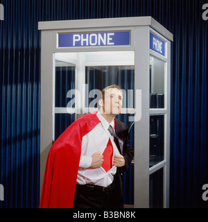 Man Opening Shirt de révéler en costume de Super Héros Phone Booth Banque D'Images