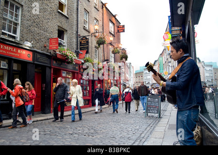 Un musicien ambulant joue de la guitare dans les rues de Temple Bar Dublin Ireland Banque D'Images