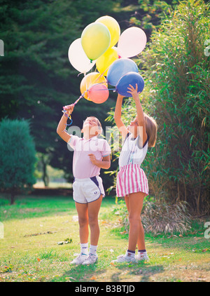 Enfants jouant avec des ballons dans un parc Banque D'Images