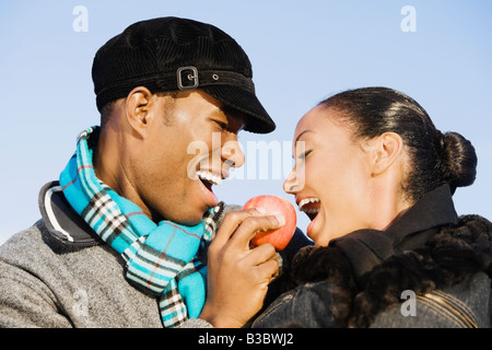 Multi-ethnic couple eating apple Banque D'Images