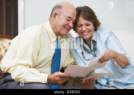 Senior Hispanic couple looking at photographs Banque D'Images