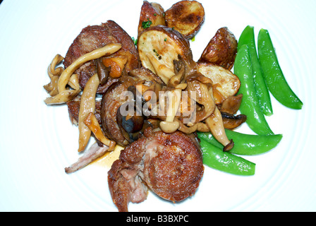 Repas gastronomique de l'épaule d'agneau cuite sous vide puis grillé pan avec un mélange de champignons sauvages et petits pois Banque D'Images