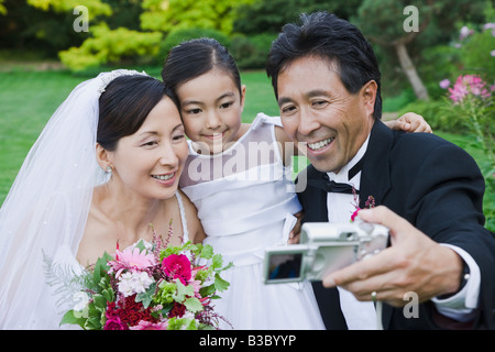 Asian newlyweds et fille taking own photograph Banque D'Images