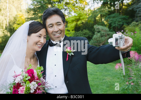 Jeunes mariés asiatiques taking own photograph Banque D'Images