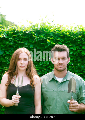 Un couple dans un jardin à la truelle permanent et la fourche Banque D'Images