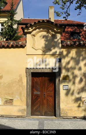 Porte en bois de couleur crème, sol carrelé en haut mur dans le quartier Josefov de Prague Banque D'Images