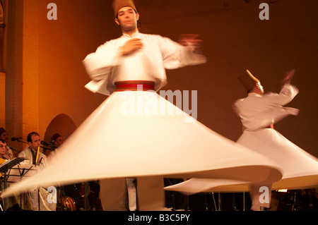 Maroc, Fes. Deux Derviches tourneurs effectuer lors d'un concert au Festival de Fès des Musiques Sacrées du Monde. Les membres de l'Ensemble Al Kindi effectuer la musique. Banque D'Images