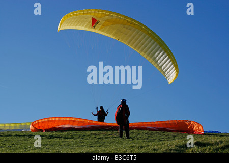 L'Angleterre, Eastbourne, East Sussex. Le parapente est un sport de vol récréatifs et compétitifs. Un parapentiste est un battant, lancé des avions. Le pilote est assis dans un harnais suspendu au-dessous un tissu d'une aile, dont la forme est constituée par la pression d'air entrant dans les évents à l'avant de l'aile. Banque D'Images