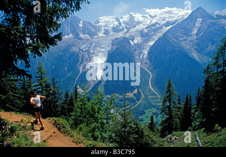 France, Haute-Savoie, Chamonix. Un Walker dirige le sentier du Tour de Pays du Mont Blanc face au Mont Blanc au-dessus de Chamonix. Banque D'Images