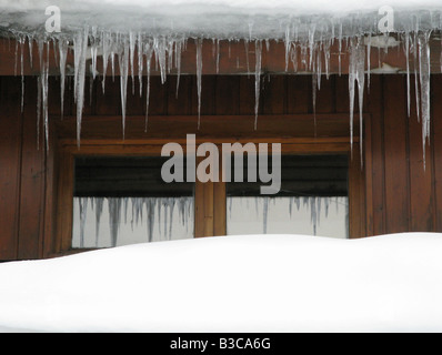 Les glaçons suspendus à un toit couvert de neige à Méribel France Banque D'Images