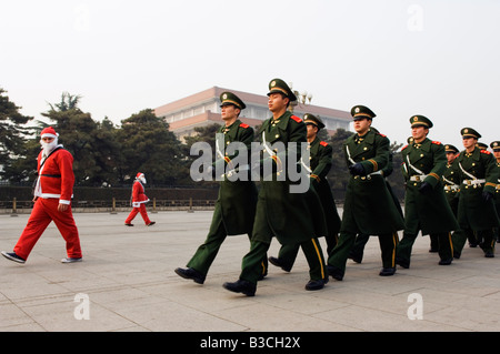 La Chine, Pékin, place Tiananmen. Les résidents étrangers habillés en Père Noël le jour de Noël en ligne avec des gardes nationaux. Banque D'Images