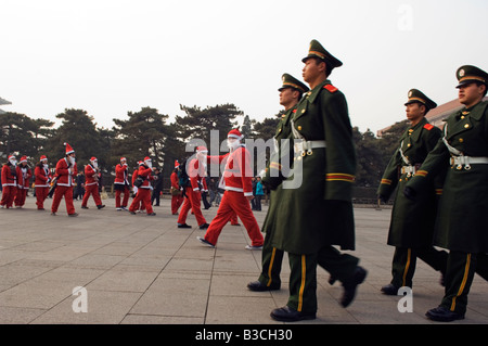 La Chine, Pékin, place Tiananmen. Les résidents étrangers habillés en Père Noël le jour de Noël en ligne avec des gardes nationaux. Banque D'Images