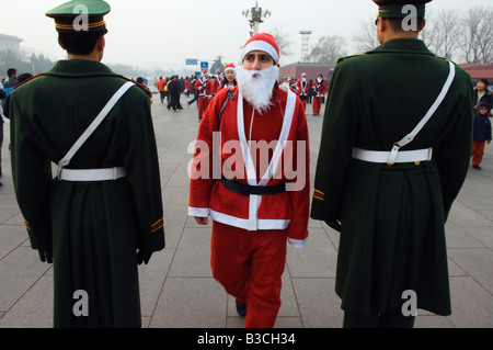 La Chine, Pékin, place Tiananmen. Un résident étranger habillé en père Noël le jour de Noël en ligne avec des gardes nationaux. Banque D'Images