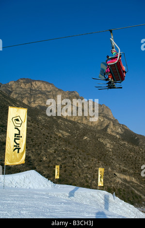 La Chine, Beijing, Shijinglong ski resort. Un ascenseur de ski skieurs prenant jusqu'à la pente. Banque D'Images