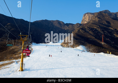 La Chine, Beijing, Shijinglong ski resort. Un ascenseur de ski skieurs prenant jusqu'à la pente. Banque D'Images