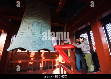 La Chine, Beijing. Nouvel An chinois Fête du Printemps - un couple célébrant la nouvelle année faire sonner la grosse cloche au Parc Ditan temple Banque D'Images