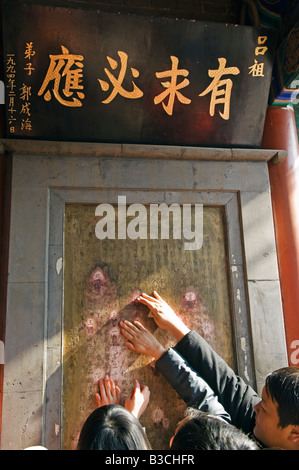 La Chine, Beijing. Nouvel An chinois - Festival de Printemps sacré insriptions fidèles de toucher au Baiyun Guan Temple taoïste du nuage blanc. Banque D'Images