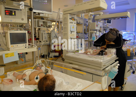 Femme religieuse inspectant son prématuré aux soins intensifs néonatals Unité Centre médical Shaare Zedek ou hôpital Shaarei Tzedek Ouest Jérusalem Banque D'Images