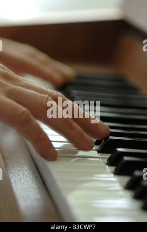 Close-up of a ma's hands playing piano Banque D'Images