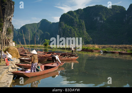 Dame vietnamienne prépare à punt voyageurs descendent la rivière à Tam Coc près de Ninh Binh Banque D'Images