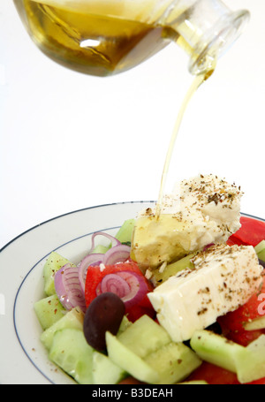 On verse de l'huile d'olive sur une salade grecque traditionnelle Banque D'Images