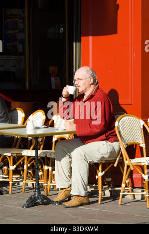 L'homme de boire du café au café terrasse Pont Audemer Normandie France Banque D'Images