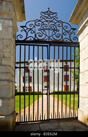 Une grande maison basque impressionnant derrière sa grande porte en fer forgé (France). Maison de l'ONU derrière basque grand portail de fer forgé Banque D'Images