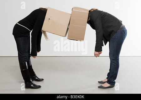 Les femmes avec des boîtes sur leur tête Banque D'Images