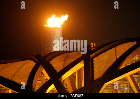 La flamme olympique brûle au-dessus le nid d'oiseau (Stade National) pendant les Jeux Olympiques d'été de 2008 à Pékin, en Chine. Banque D'Images