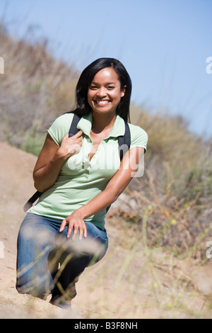 Femme accroupie sur le chemin beach smiling Banque D'Images