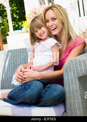 Femme et de la jeune fille assise sur patio laughing Banque D'Images