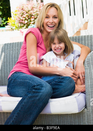 Femme et de la jeune fille assise sur patio laughing Banque D'Images