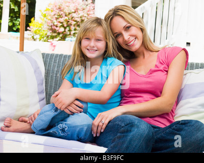 Femme et de la jeune fille assise sur patio smiling Banque D'Images