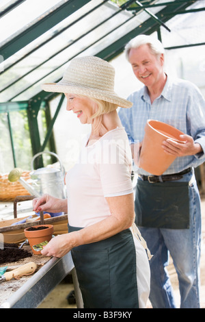 Femme en émissions de planter des graines et pot man smiling Banque D'Images