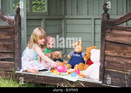 Jeune fille dans hangar avec un plateau de jeu de bébé Banque D'Images