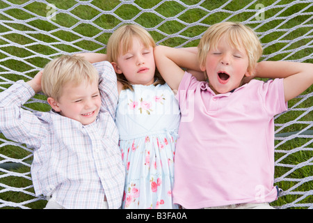 Trois enfants se détendre et dormir en hamac Banque D'Images