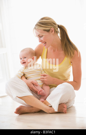 La mère et l'enfant assis à l'intérieur smiling Banque D'Images