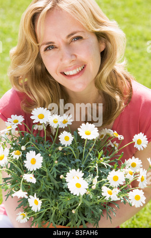 Woman holding Flowers smiling Banque D'Images