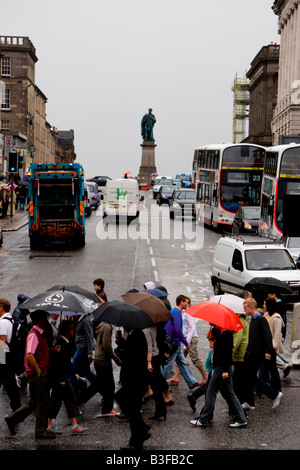 Les personnes qui traversent la route sur un matin humide à la jonction de la rue Princes Street et Hanover Street à Édimbourg, Écosse Banque D'Images