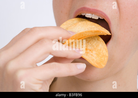 Woman eating crisps Banque D'Images