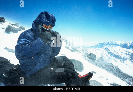 D'alpiniste exposée à de forts vents et de la neige sur Pastuckhov Rochers à 4690m sur la voie normale pour le sommet du mont Elbrouz Banque D'Images