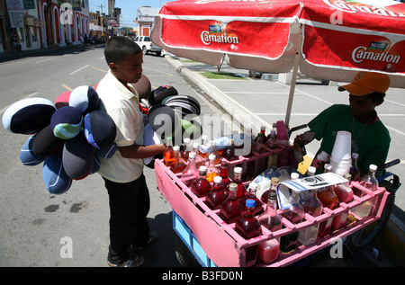 Les jeunes garçons vente de boissons et vejigas durant Carnaval Vegano à La Vega, République Dominicaine Banque D'Images