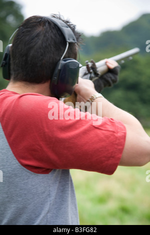 Homme tenant le pointage visant Shotgun à Chatsworth Country Fair Derbyshire, Royaume-Uni Banque D'Images