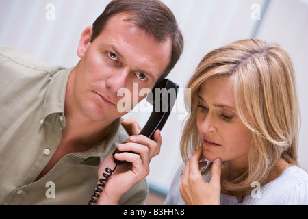 Couple recevant un appel téléphonique de mauvaises nouvelles de la clinique Banque D'Images