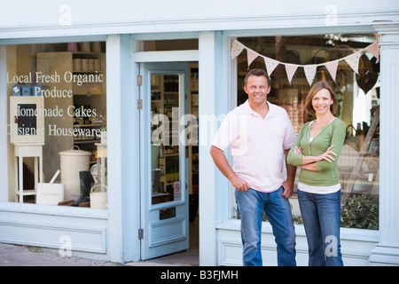 Couple standing in front of organic food store smiling Banque D'Images