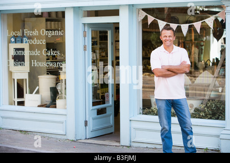 Man standing in front of organic food store smiling Banque D'Images