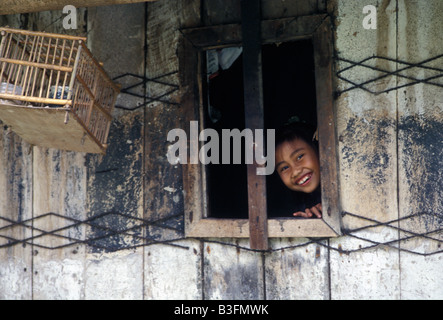 Fille à karo batak fenêtre maison village dokan sumatra indonésie Banque D'Images