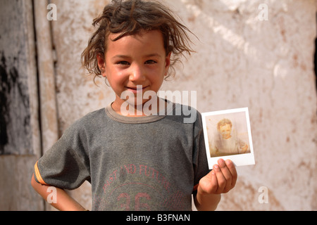 Petite fille bédouine montrant un polaroid de son, la Syrie Banque D'Images