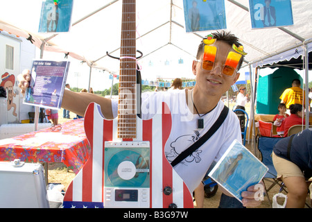 Homme Hmong de 21 ans porte des lunettes décoratives vend des disques de musique sur CD. Sports Festival Hmong McMurray Domaine St Paul Minnesota USA Banque D'Images